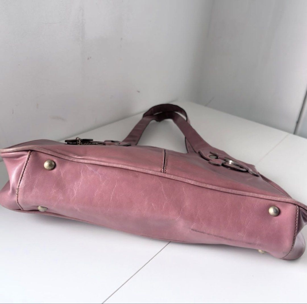 Rina Rich Pink Handbag Shoulder Bag (Category: Shoulder Bags) located in Calamba. Submitted by thethriftdame (Listing ID 1470244949, Image 3). Description: - Brand/Model: Rina Rich Handbag in Dusty Pink - Style: Trendy Y2K aesthetic with a structured design and center seam - Details: Chic circular metal ring accents and a matching heart charm on a chain - Interior: Fabric-lined with convenient zipper pockets - Protection: Fitted with bottom feet 