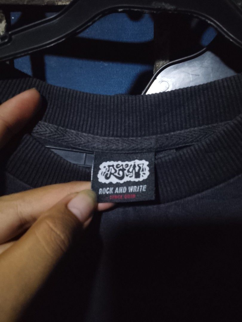 Rock And Write Black Graphic T-Shirt (Category: Tshirts & Polo Shirts ) located in Manila. Submitted by warmcloud-06f3 (Listing ID 1470216901, Image 3). Description: - Brand: Rock And Write (Est. 2018) - Color: Classic Black - Design: Small graffiti hand can print on the chest with a large graffiti text logo across the back - Details: Ribbed crew neck collar and authentic brand neck label inside - Condition: Brand new / Excellent quality - Perfec