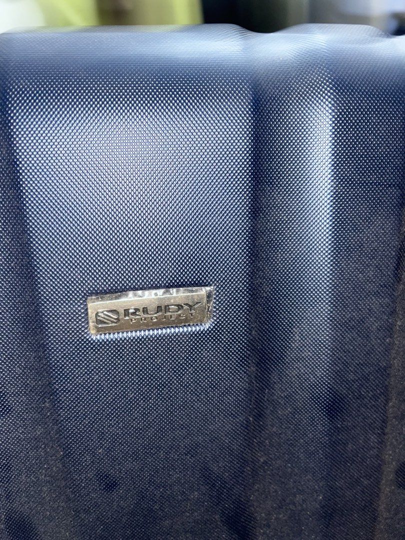 Rudy project luggage (Category: Luggage) located in Marikina City. Submitted by patpatndls (Listing ID 1470271291, Image 2). Description: - Brand: Rudy Project - Size: Medium (approx. 23-24 inches) - Color: Dark blue/black - Material: Durable hardcase exterior - Security: Built-in TSA lock - Interior: Clean grey lining with Rudy Project branding, mesh compartments, and cross straps - Mobility: Smooth-rolling wheels - Condition: Good (4/5) - Meetu