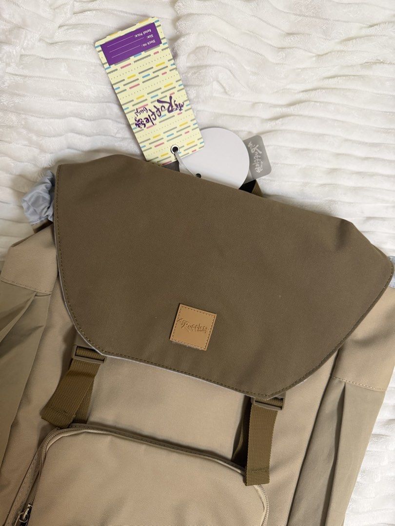 Ruffles by Co Co Beige Brown Flap Backpack Bag (Category: Backpacks) located in Rizal. Submitted by kianapreloves (Listing ID 1470221526, Image 2). Description: - Brand: Ruffles by Co Co (Brand tags still attached) - Color: Chic beige and brown - Closure: Flap top with secure drawstring inner cinch - Pockets: Front zip pocket, interior zippered mesh pocket, and extra organization slots - Comfort & Safety: Padded shoulder straps equipped with refl