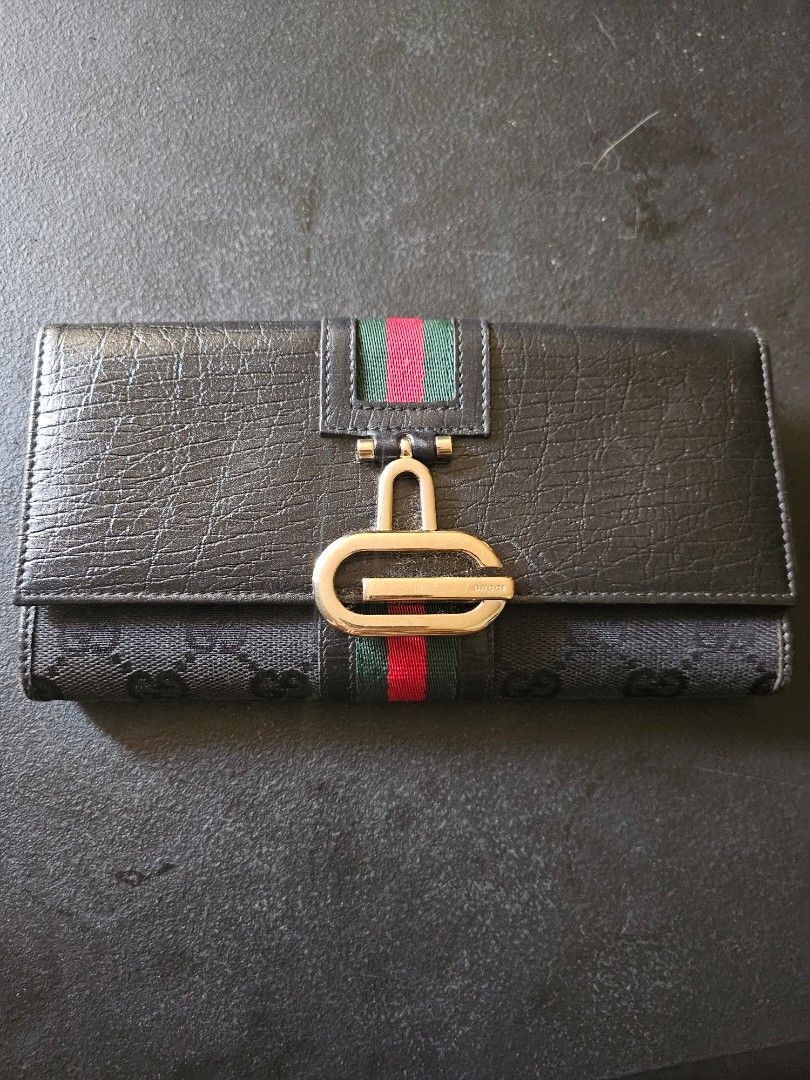 RUSH! Gucci Monogram Continental Flap Long Wallet (Category: Luxury Bags & Wallets) located in Pasig City. Submitted by allstarkenny25 (Listing ID 1470204235, Image 1). Description: - Brand: Gucci - Style: Long wallet - Material: Black monogram canvas and textured leather - Design: Iconic red and green web stripe with gold-tone hardware clasp - Interior: Multiple card slots and spacious cash compartments with stamped Gucci logo - Condition: Class