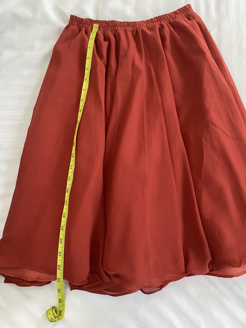 Rust Orange Pleated Midi Skirt Elastic Waist (Category: Skirts) located in Calamba. Submitted by aninmilo (Listing ID 1470184355, Image 3). Description: - Color: Rust Orange - Style: Flowy midi skirt with a handkerchief hemline - Waistband: Gathered elastic waistband for comfort (stretches to approx. 13" flat) - Lining: Fully lined to prevent any transparency - Length: Approx. 25.5" from top to bottom.