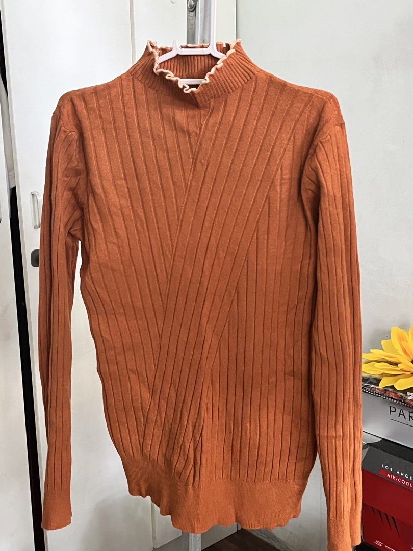 Rust Orange Ribbed Knit Sweater with Ruffled Mock Neck (Category: Coats, Jackets and Outerwear) located in Manila. Submitted by loveemjmaria (Listing ID 1470194843, Image 2). Description: Ribbed knit sweater in rich rust orange. Mock neckline featuring contrasting light beige ruffled trim. Long sleeves with vertical ribbing throughout the body. Stretchy fabric, great layering piece for cooler weather. Clean knit texture on cuffs and hem. RFS: Doe