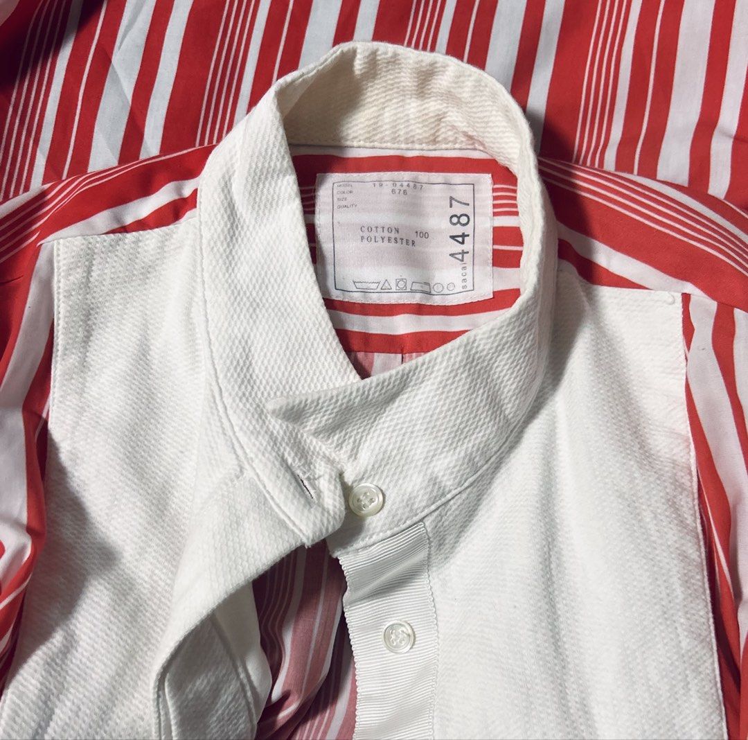 SACAI (Category: Shirts) located in Davao. Submitted by sart0ria85 (Listing ID 1470191283, Image 3). Description: Orange and white vertical stripes with white front bib panel. Stand collar, side zippers revealing pleated white fabric underneath. 100%COTTON / Mesh on the bottom side is made of Polyester and Cotton blend. MADE IN JAPAN 🇯🇵 SMALL. Size 4 Armpit to Armpit: 34inches circumference Length: 26inches EXCELLENT CONDITION (92/100).