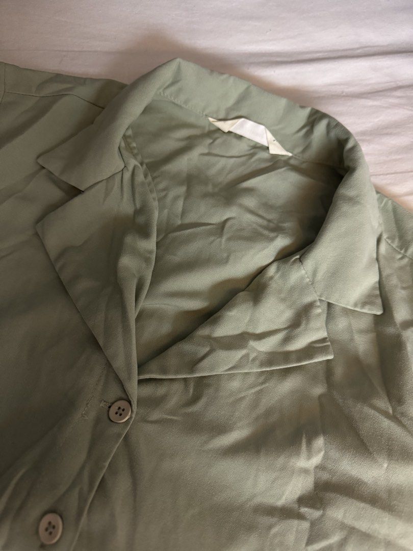 Sage Green Short Sleeve Button Down Shirt (Category: Shirts) located in Manila. Submitted by carmela_andd (Listing ID 1470318370, Image 3). Description: - Color: Sage green - Style: Short-sleeve button-down with camp collar - Fit: Relaxed and comfortable - Details: Light-colored front buttons, inner back collar tag - Versatility: Neutral solid color that matches easily with various bottoms - Condition: Great everyday casual staple piece.