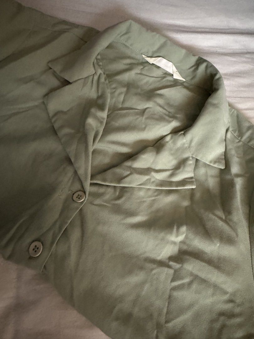 Sage Green Short Sleeve Button Down Shirt (Category: Shirts) located in Manila. Submitted by carmela_andd (Listing ID 1470318370, Image 2). Description: - Color: Sage green - Style: Short-sleeve button-down with camp collar - Fit: Relaxed and comfortable - Details: Light-colored front buttons, inner back collar tag - Versatility: Neutral solid color that matches easily with various bottoms - Condition: Great everyday casual staple piece.