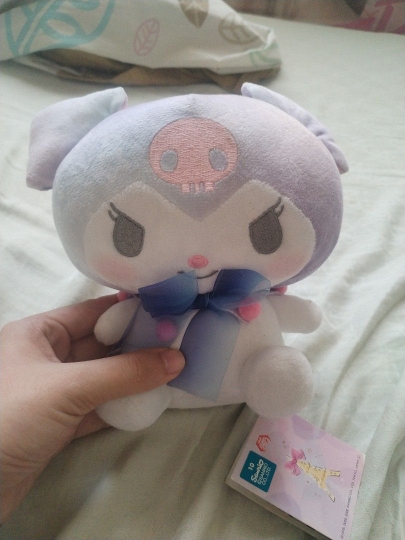 Sanrio Kuromi Plush Toy (Category: Plushies & Soft Toys) located in Davao. Submitted by belles_pre_loved (Listing ID 1470157587, Image 1). Description: - Authentic FuRyu Sanrio Kuromi plush toy - Rare light purple and white color scheme with a cute blue ribbon - Sitting pose, made with ultra-soft fabric - Features original paper tag with My Melody and Kuromi artwork - Tush tag intact, dated Sanrio 2005, 2020.