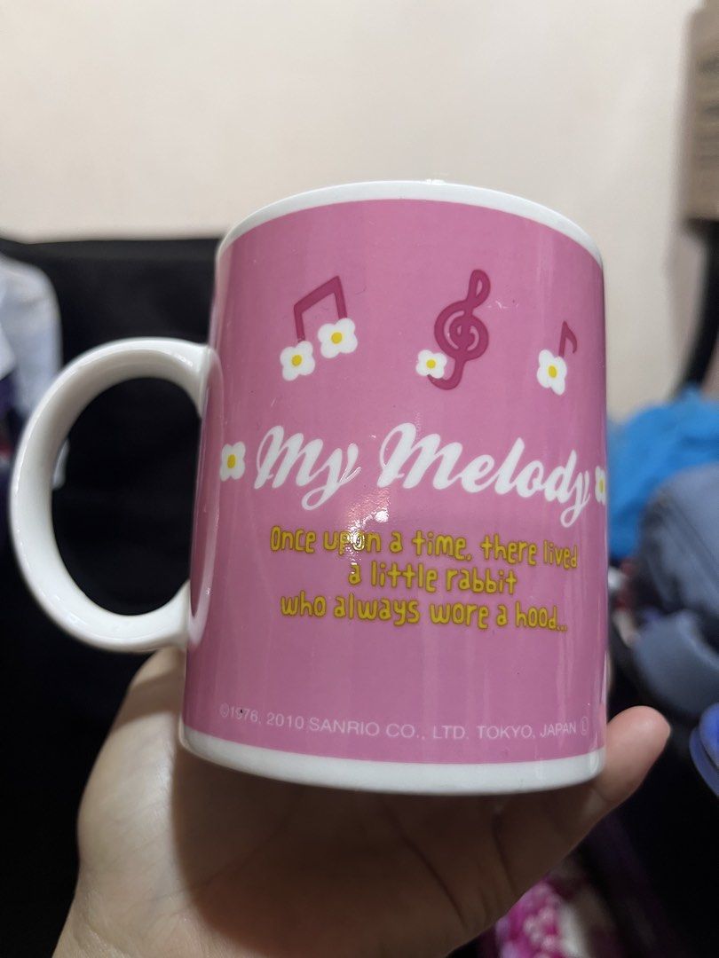 Sanrio My Melody Ceramic Mug (Category: Coffee & Tea Tableware) located in Manila. Submitted by janetecson05 (Listing ID 1470206425, Image 2). Description: - Authentic Sanrio My Melody official merchandise (Dated 1976, 2010) - Charming pink ceramic mug with My Melody front graphic - Back features musical notes and a cute story quote - Handle includes delicate script writing and flower details - Inner rim decorated with tiny musical notes - Standa