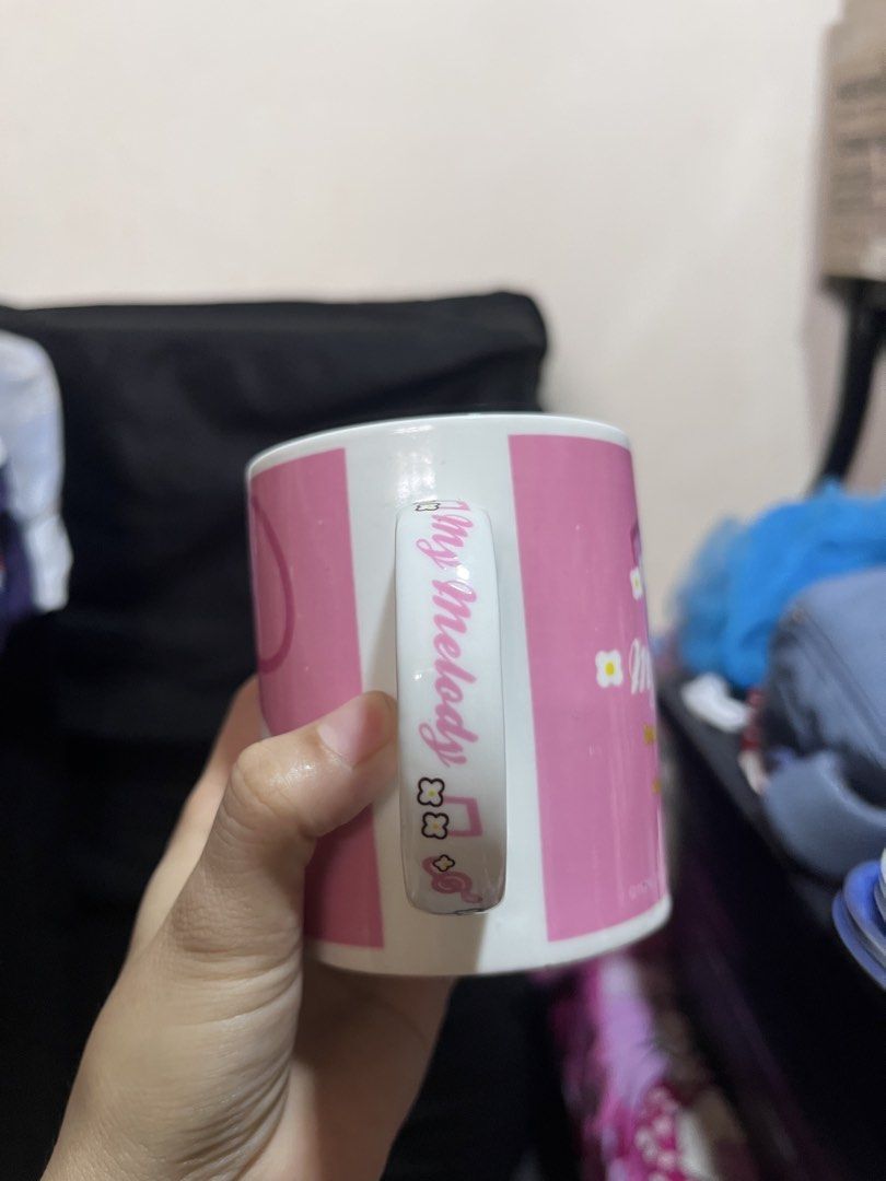 Sanrio My Melody Ceramic Mug (Category: Coffee & Tea Tableware) located in Manila. Submitted by janetecson05 (Listing ID 1470206425, Image 3). Description: - Authentic Sanrio My Melody official merchandise (Dated 1976, 2010) - Charming pink ceramic mug with My Melody front graphic - Back features musical notes and a cute story quote - Handle includes delicate script writing and flower details - Inner rim decorated with tiny musical notes - Standa