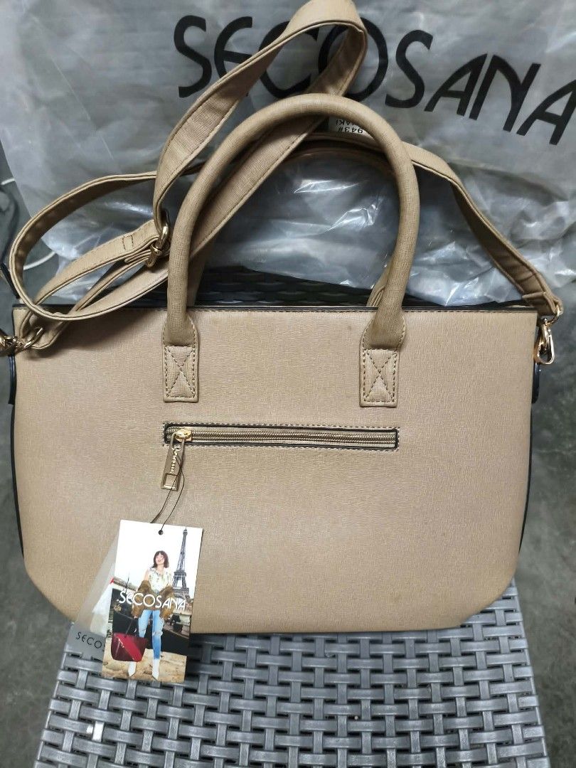 Secosana Khaki Handbag with Tag (Category: Luxury Bags & Wallets) located in Manila. Submitted by marielcari00032 (Listing ID 1470200338, Image 2). Description: - Brand: Secosana - Color: Khaki - Material: Premium faux leather - Condition: Brand new with store tag attached, never used, and clean interior - Design: Structured shape with sleek metal branding plate - Carry options: Dual top handles and a detachable shoulder strap - Storage: Exterior