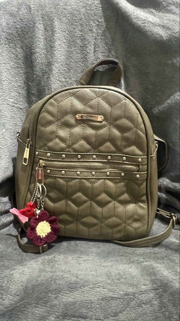 Secosana Olive Green Quilted Backpack with Studs (Category: Backpacks) located in Manila. Submitted by asdfghjkl.mountain (Listing ID 1470277988, Image 2). Description: - Brand: Secosana - Color: Olive Green - Material: Textured faux leather with quilted hexagonal front pattern - Hardware: Gold-tone accents with Secosana logo plate & silver-toned metal stud details on the front pocket - Storage: Multiple zipper compartments on the front and back 