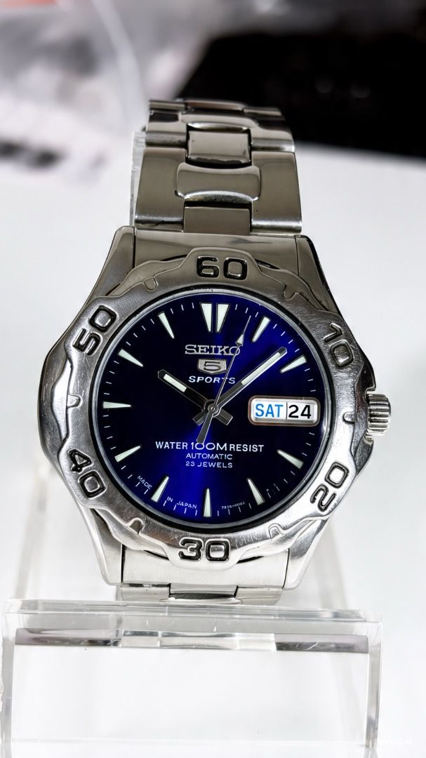 Seiko 5 Sports Automatic Watch 7S36-00A0 Blue Dial (Category: Men's Watches) located in Caloocan City. Submitted by imlei (Listing ID 1470301538, Image 1). Description: Seiko 5 Sports automatic watch. Deep blue sunburst dial with luminous hands and markers. Day and date window at the 3 o'clock position. Stainless steel case and matching metal bracelet. Exhibition case back displaying the 23 jewels 7S36 movement. Rotating bezel with engraved numbe
