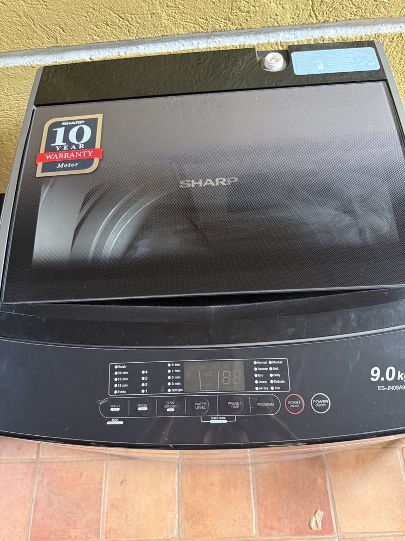 Sharp ES-JN09A9 9.0kg Top Load Washing Machine (Category: Washing Machines and Dryers) located in Quezon City. Submitted by sbcarrot (Listing ID 1470278838, Image 2). Description: - Brand/Model: Sharp 9.0kg Top Load Washing Machine - Color: Dark grey body with premium black glass lid - Control Panel: User-friendly digital display with multiple wash programs, water levels, and preset timers - Warranty: Includes 10-year motor warranty badge - Condi