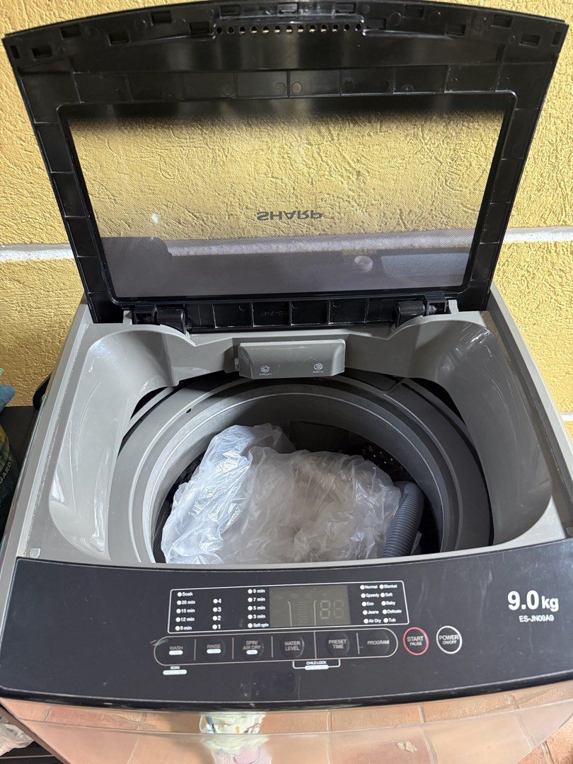 Sharp ES-JN09A9 9.0kg Top Load Washing Machine (Category: Washing Machines and Dryers) located in Quezon City. Submitted by sbcarrot (Listing ID 1470278838, Image 3). Description: - Brand/Model: Sharp 9.0kg Top Load Washing Machine - Color: Dark grey body with premium black glass lid - Control Panel: User-friendly digital display with multiple wash programs, water levels, and preset timers - Warranty: Includes 10-year motor warranty badge - Condi