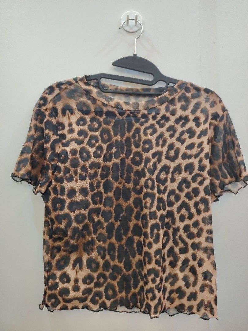 SHEIN Curve Leopard Print Mesh Tee Size 0XL (Category: Sleeveless) located in Manila. Submitted by babeboxtheory (Listing ID 1470295902, Image 2). Description: - Brand/Style: SHEIN Curve leopard print mesh top - Size: 0XL (tag attached) - Design: Short sleeves, round neckline, and trendy lettuce trim edges - Fabric: Sheer animal print mesh (94% polyester, 6% elastane) - Features: Lightweight, stretchy, and makes a great layering piece - Care: Han