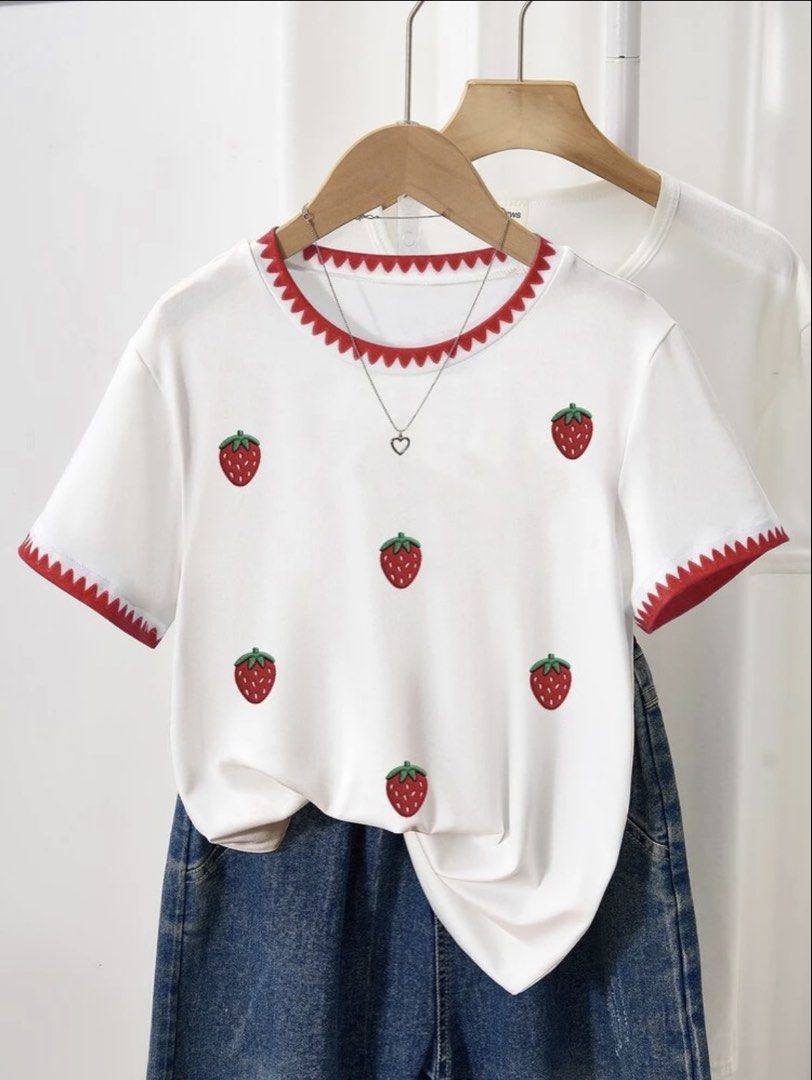 Shein White strawberry shirt (Category: Shirts) located in Manila. Submitted by dianafayesimbre (Listing ID 1470269508, Image 1). Description: - Color: Crisp white with red scalloped trim - Design: Embroidered strawberry pattern on the front, plain back - Fit: Short-sleeve crew neck, casual everyday style - Styling: Great to pair with high-waisted denim or skirts - Condition: Brand new - Size 11Y on tag but fits xs to semi L.