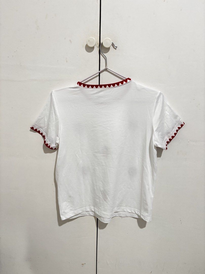 Shein White strawberry shirt (Category: Shirts) located in Manila. Submitted by dianafayesimbre (Listing ID 1470269508, Image 3). Description: - Color: Crisp white with red scalloped trim - Design: Embroidered strawberry pattern on the front, plain back - Fit: Short-sleeve crew neck, casual everyday style - Styling: Great to pair with high-waisted denim or skirts - Condition: Brand new - Size 11Y on tag but fits xs to semi L.