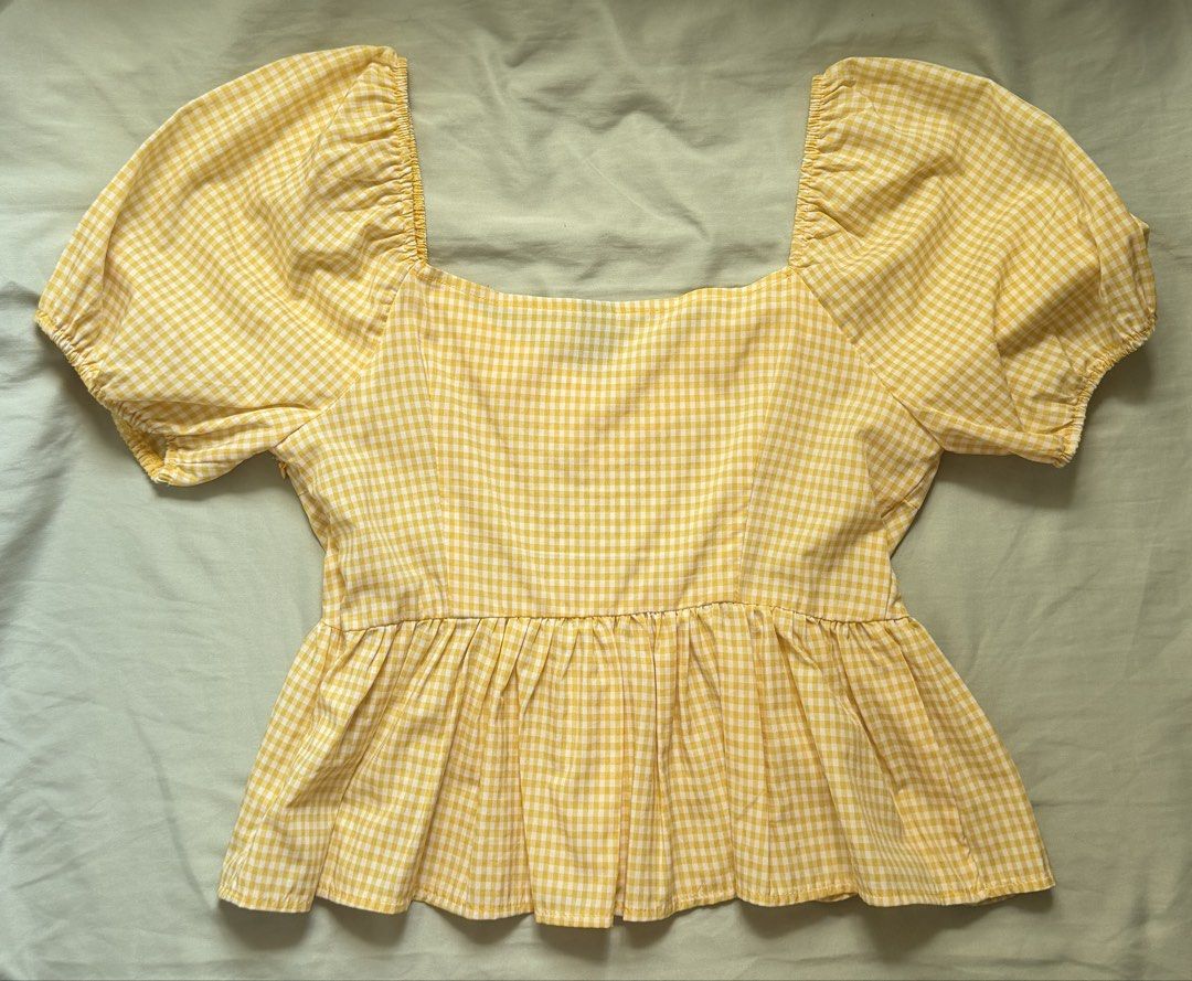 SHEIN Yellow Gingham Peplum Blouse (Category: Blouses) located in Dinalupihan. Submitted by wonmeoww (Listing ID 1470250223, Image 3). Description: - Brand: Shein - Design: Yellow and white checkered pattern - Details: Square neckline, short puff sleeves, and ruffled hem - Closure: Convenient side zipper - Fit: Fitted bodice with a flared waist - Condition: Excellent / Like new - Mode of Payment: GCash.
