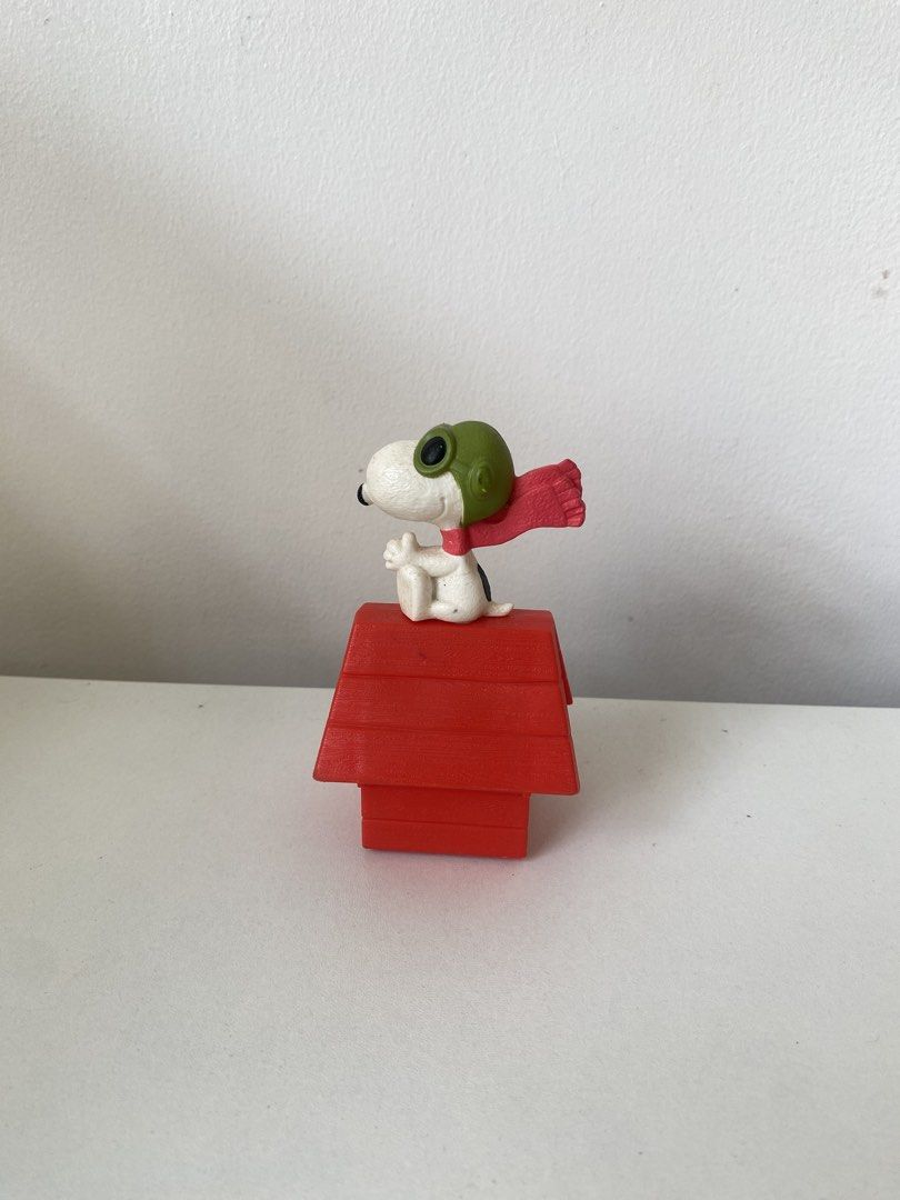 Snoopy Flying Ace on Red Doghouse Figurine (Category: Figurines & Statues) located in Muntinlupa City. Submitted by bajisuke (Listing ID 1470148966, Image 1). Description: - Item: Snoopy on Red Doghouse Figure - Details: Wearing a green aviator cap and red scarf - Condition: Clean paint, no major scuffs, stands firmly upright - Ideal for: Peanuts collectors and cute desk displays.