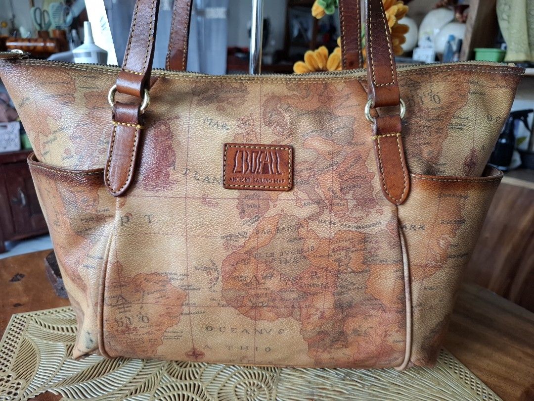 SOBDEAL Ancient Sailing Map Tote Bag (Category: Tote Bags) located in Libon. Submitted by jaladzarmi80045 (Listing ID 1470207211, Image 2). Description: - Authentic Sondeal tote bag - Eye-catching ancient sailing map print all over - Durable brown leather handles and trim with gold hardware - Secure zip top closure - Convenient external side pockets for quick access - Roomy interior, perfect as an everyday carryall.