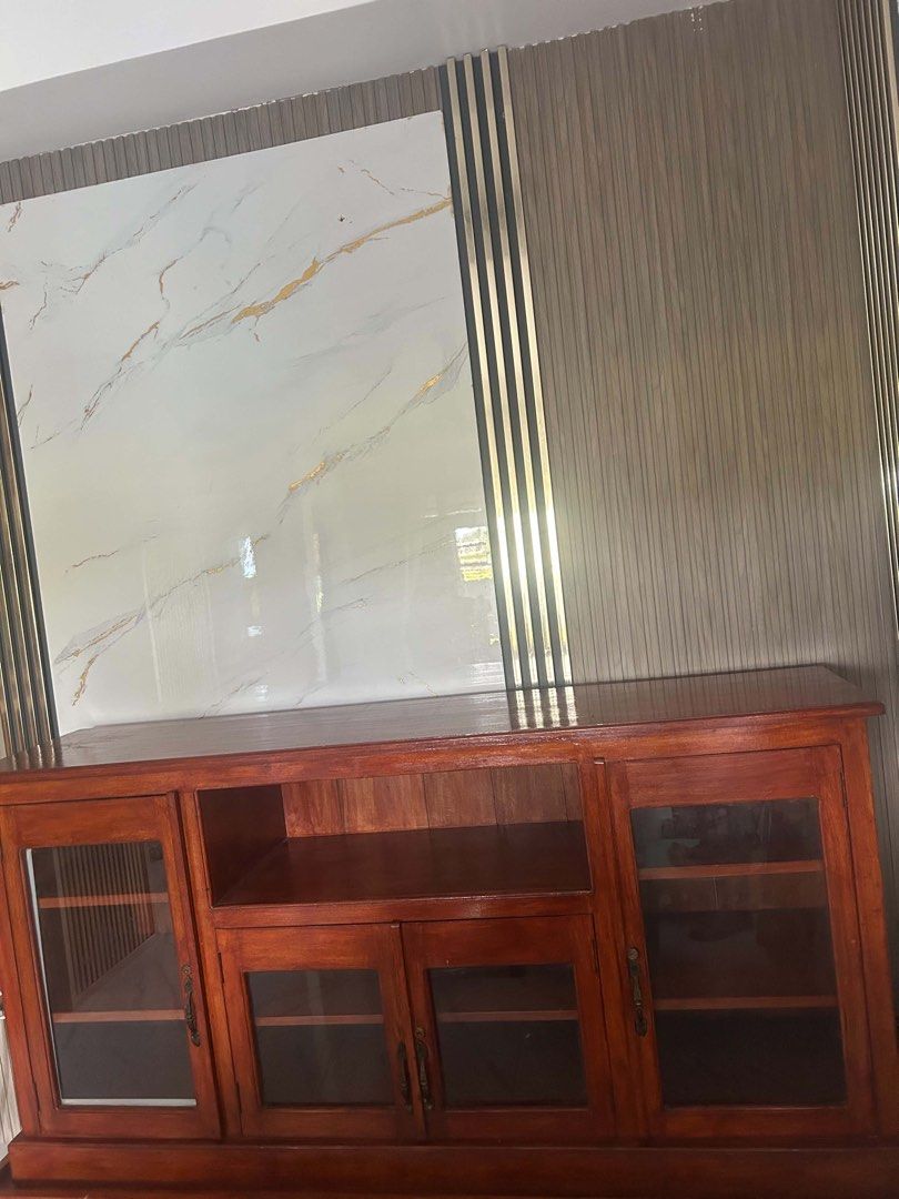 Solid Wood TV Console with Glass Doors and Shelves (Category: TV Consoles) located in Mandaluyong City. Submitted by l2ayne (Listing ID 1470220667, Image 2). Description: TV Console with Glass Doors and Shelves- Mahogany Wood Rich brown wood finish with a heavy, sturdy build - Features elegant glass panel doors and ornate vintage-style handles - Open shelving in the middle for easy device access - Spacious cabinets for storing media gear, books, 
