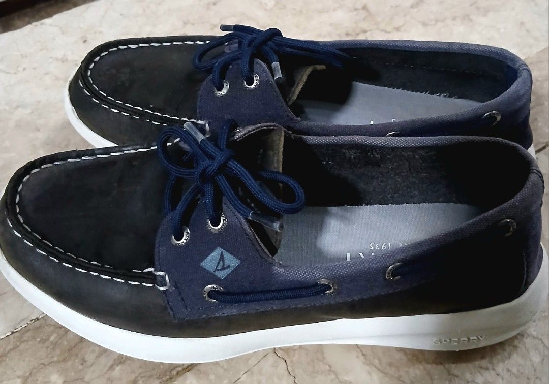Sperry Boat Shoes Navy Blue (Category: Casual Shoes) located in Quezon City. Submitted by mrs.maria (Listing ID 1470230393, Image 2). Description: - Brand: Sperry - Style: Boat shoes / Casual footwear - Color: Navy blue and black leather mix - Features: Blue lace-up closure with metal eyelets, memory foam insoles for all-day comfort, and white rubber soles with wave-siping for superior grip - Condition: Shows slight creasing on the uppers and nor