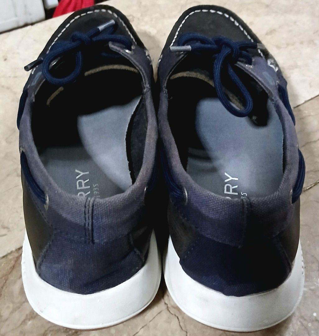 Sperry Boat Shoes Navy Blue (Category: Casual Shoes) located in Quezon City. Submitted by mrs.maria (Listing ID 1470230393, Image 3). Description: - Brand: Sperry - Style: Boat shoes / Casual footwear - Color: Navy blue and black leather mix - Features: Blue lace-up closure with metal eyelets, memory foam insoles for all-day comfort, and white rubber soles with wave-siping for superior grip - Condition: Shows slight creasing on the uppers and nor