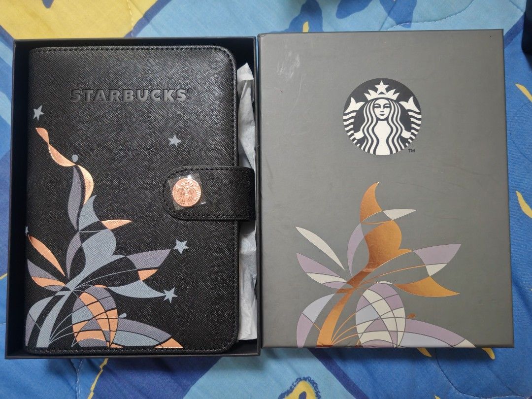 Starbucks Black Planner With Box (Category: Stationery & School Supplies) located in Makati City. Submitted by brooklyn87370 (Listing ID 1470205559, Image 1). Description: - Brand new and never used, kept safely in its box - Elegant black cover with peach, grey, and white abstract floral art and scattered star prints - Secure metallic rose gold clasp featuring the iconic Starbucks siren logo - Includes a matching grey presentation box with the sa
