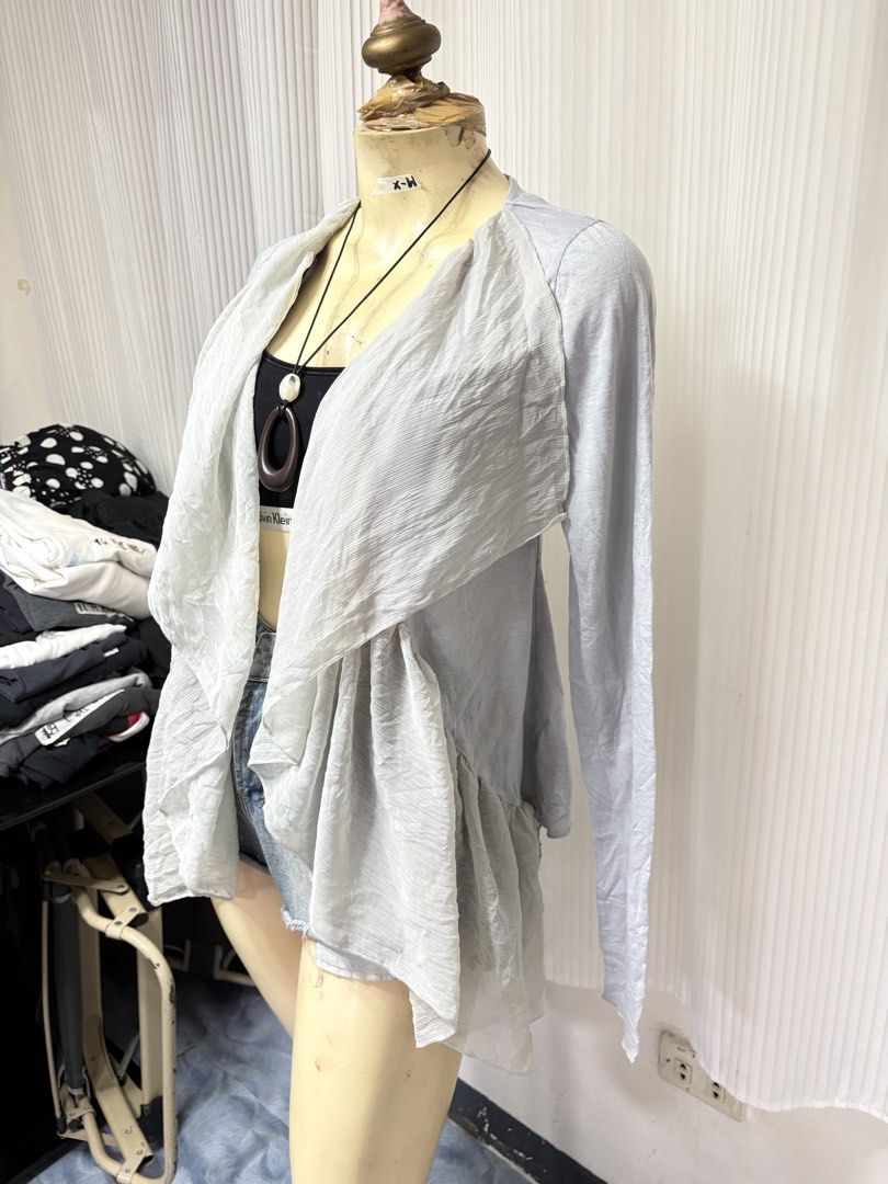 Steve Madden Grey Open Front Cardigan (Category: Coats, Jackets and Outerwear) located in General Trias. Submitted by crissy9053136 (Listing ID 1470229654, Image 2). Description: - Brand: Steve Madden - Color: Light Grey - Size: CH - Material: Textured, crinkled lightweight fabric - Design: Open front with draped ruffled lapels and long sleeves - Hem: Asymmetrical (longer in the back) - Perfect for layering over crop tops or camis.