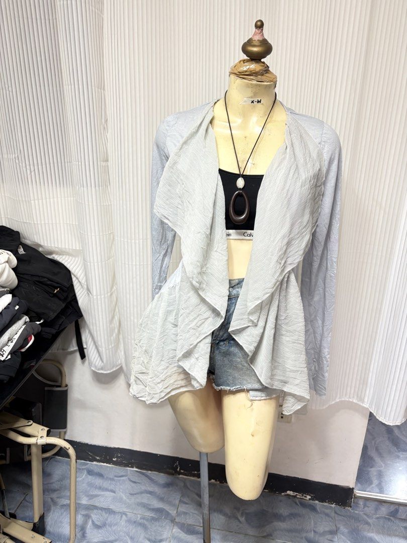 Steve Madden Grey Open Front Cardigan (Category: Coats, Jackets and Outerwear) located in General Trias. Submitted by crissy9053136 (Listing ID 1470229654, Image 1). Description: - Brand: Steve Madden - Color: Light Grey - Size: CH - Material: Textured, crinkled lightweight fabric - Design: Open front with draped ruffled lapels and long sleeves - Hem: Asymmetrical (longer in the back) - Perfect for layering over crop tops or camis.