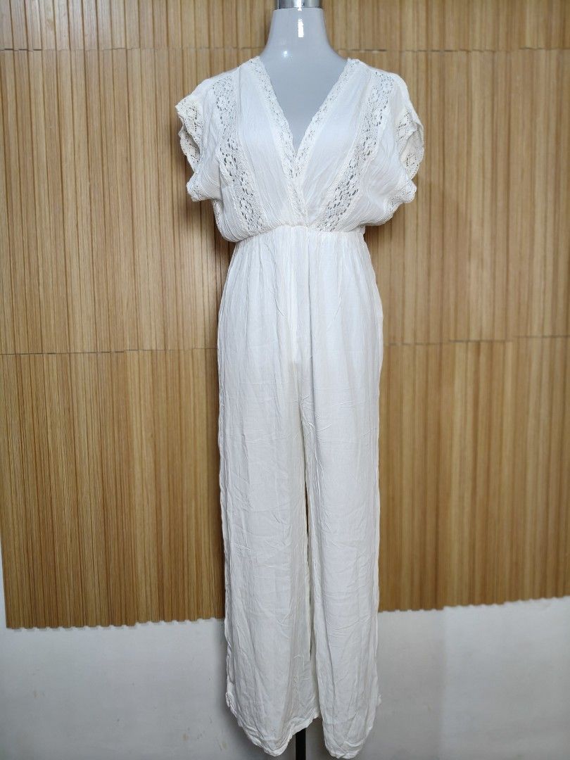 Stradivarius White Lace Trim Jumpsuit (Category: Jumpsuits) located in Taguig. Submitted by ashie_clothing (Listing ID 1470287101, Image 3). Description: - Brand: Stradivarius - Size: M - Color: White - Design: V-neck with delicate lace trim on neckline and sleeves - Fit: Relaxed fit with a trendy wide-leg cut - Condition: Brand new with tags (BNWT) - Original Price: ₱2,795 - Origin: Made in India.