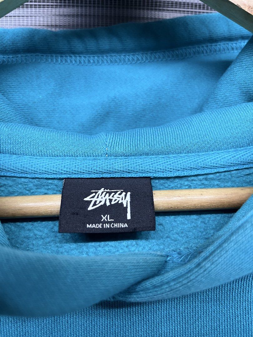 Stussy Basic Logo Teal Hoodie XL (Category: Coats, Jackets and Outerwear) located in Angeles City. Submitted by calmstar_407931 (Listing ID 1470332787, Image 3). Description: - Brand: Stussy - Style: Pullover hoodie with drawstring hood and kangaroo pocket - Color: Bright teal blue - Size: XL - Details: Small signature chest logo and oversized back print - Material: Heavyweight fleece lining inside - Condition: Excellent.