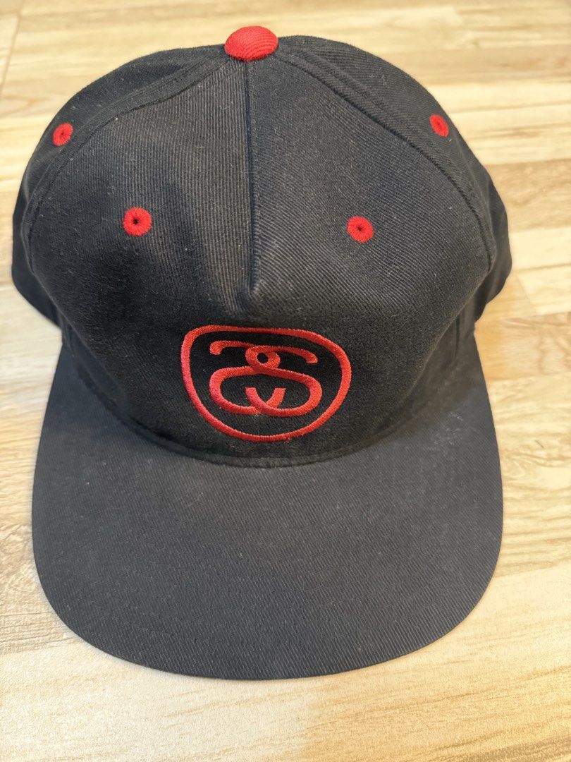 Stussy link cap (Category: Caps & Hats) located in Manila. Submitted by safeowl.b6dbb0 (Listing ID 1470337331, Image 1). Description: - Authentic Stussy black baseball cap - Bold red embroidered logo on the front - Matching red eyelets and top button - Adjustable snapback closure for a custom fit - 100% premium cotton material with interior tag - Features hologram authenticity sticker on the brim - Clean interior lining with white front panels - 