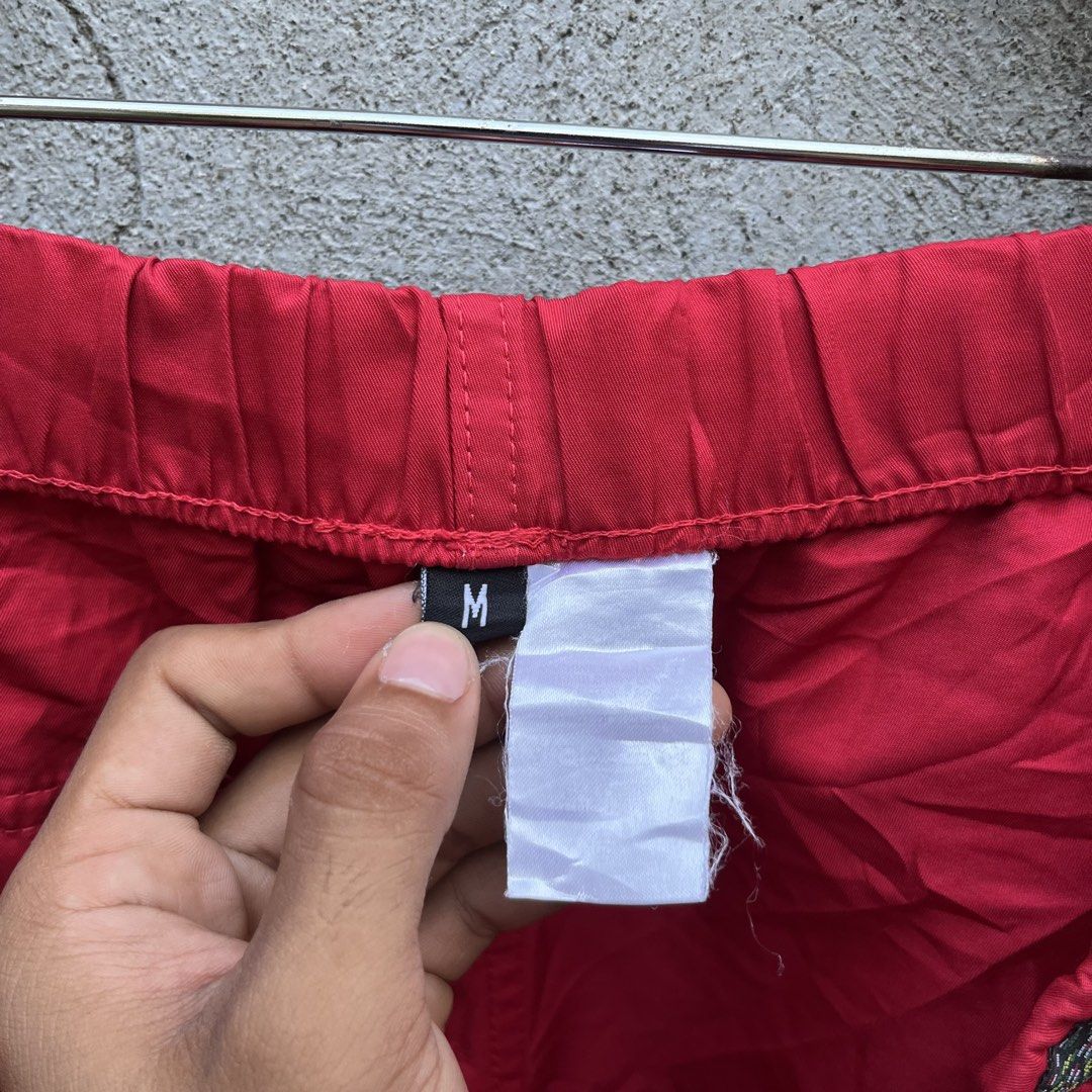 Stussy Red Nylon Shorts Size M (Category: Shorts) located in Davao. Submitted by streetsight (Listing ID 1470298681, Image 3). Description: - Brand: Stussy - Color: Bright Red - Size: Medium (M) - Material: Lightweight nylon, ideal for casual wear - Waistband: Elastic with stylish patterned trim detail - Branding: Small embroidered signature logo near hem and Stussy-embossed metal eyelets - Condition: Brand new with inner tags attached.
