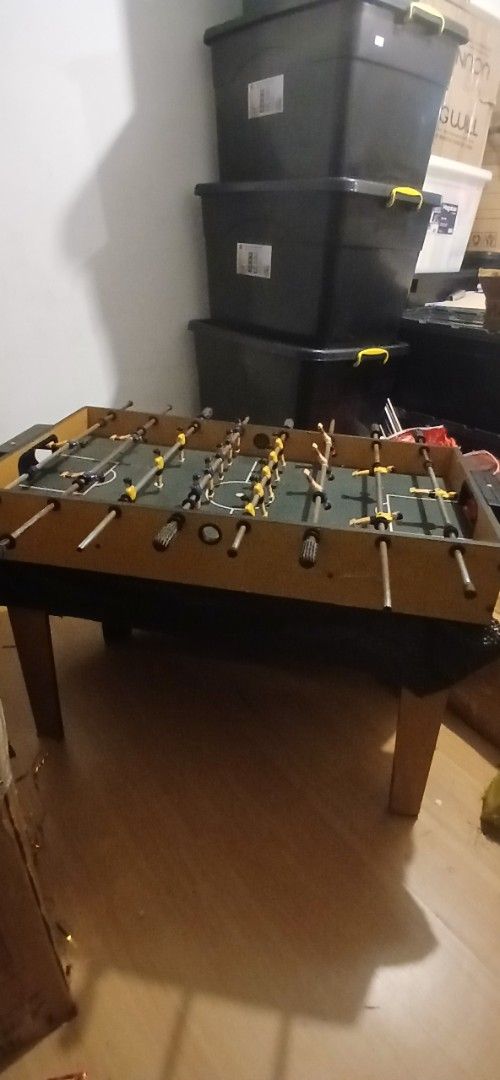 Tabletop Foosball Table with Blue and Yellow Players (Category: Board Games & Puzzles) located in San Juan City. Submitted by frugalmomph (Listing ID 1470170334, Image 1). Description: - Type: Mini tabletop foosball game - Design: Wooden finish cabinet with green pitch markings - Components: Metal rods, plastic handles, and yellow/blue players - Condition: Fully assembled and ready to play, with some light scuffs from normal use - Perfect for: Ga