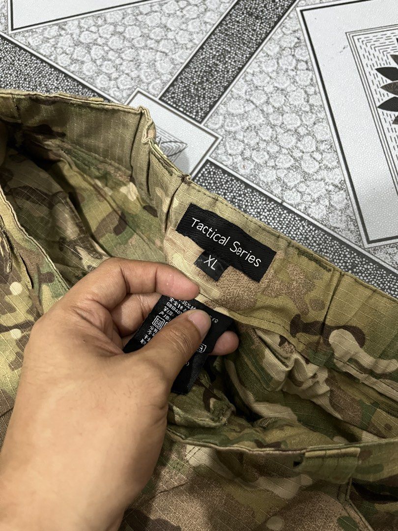 Tactical Series Multicam Camouflage Cargo Pants (Category: Jeans) located in Quezon City. Submitted by flip_da_cash (Listing ID 1470156286, Image 3). Description: - Size: XL (labeled at inner waistband) Waist: 34 Length: 39 Hem: 10 - Pattern: Multicam camouflage - Material: Durable ripstop fabric for long-lasting wear - Pockets: Multiple utility cargo pockets and back flap pockets with reinforced construction - Closure: Waistband with belt loops 