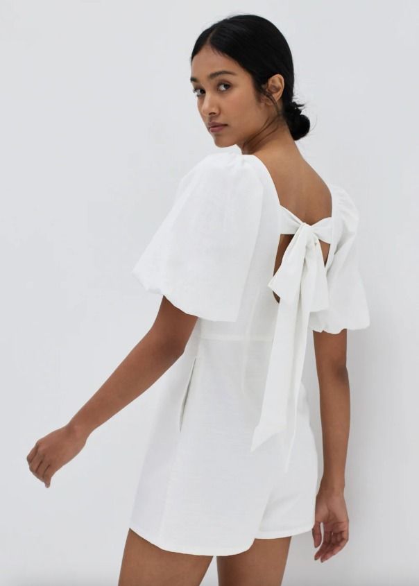 Taye Puff Sleeve Tie Back Romper (Category: Rompers) located in Manila. Submitted by sofia.uy7 (Listing ID 1470287340, Image 3). Description: BRAND NEW (never worn) Love, Bonito Taye Puff Sleeve Tie Back Romper Color: White Size: Medium Length: 30.5 inch Bust: 36 inch Waist: 28.5 inch Your favourite warm-weather style staple. Made from textured fabric, this casual romper features a V-neckline and is worn at a comfortable mini length. Accentuated 