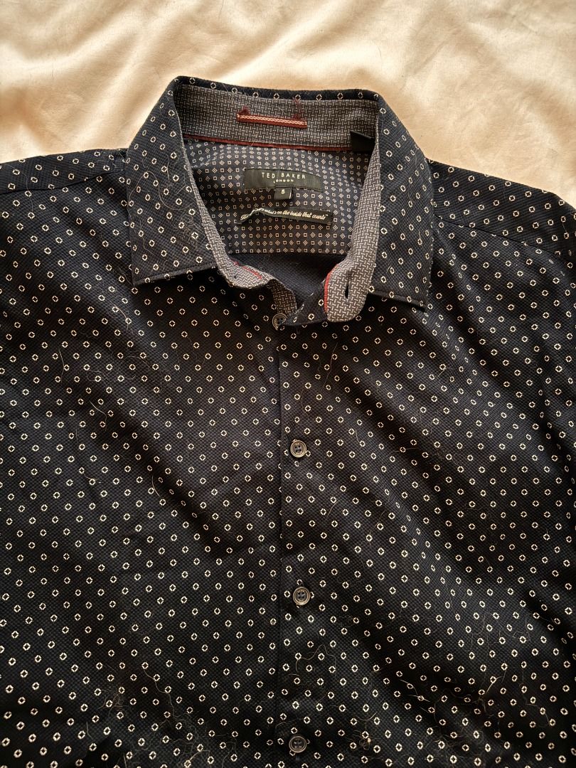 Ted Baker London geometric print button-down shirt Large (Category: Blouses) located in Cebu City. Submitted by _t.rix (Listing ID 1470186662, Image 3). Description: - Brand: Ted Baker London - Style: Men's long-sleeve button-down shirt - Color/Pattern: Dark navy blue with all-over white geometric print - Size: Tagged Size 5 (Large) - Material: 98% cotton, 2% elastane (slight stretch for comfort) - Details: Contrasting inner collar/trim with red 