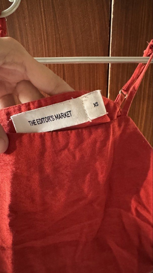 The Editor's Market Top (Category: Sleeveless) located in Las Pinas. Submitted by crlne (Listing ID 1470230733, Image 3). Description: - Brand: The Editor's Market - Size: XS - Color: Red - Design: Square neckline, thin adjustable straps, and side button placket with four brown buttons - Fabric: Lightweight, ideal for warm weather or layering - Condition: Minor wear near the arm opening, otherwise clean and ready to wear.
