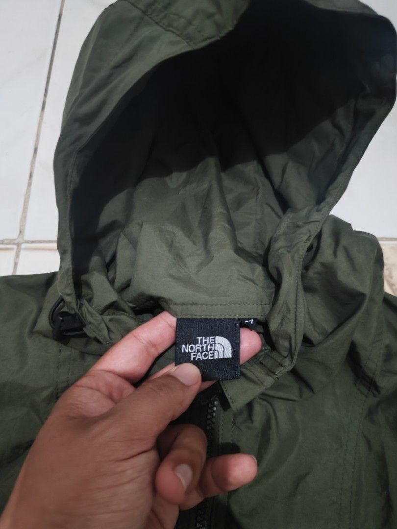 The North Face packable Windbreaker water repellent Jacket (Category: Coats, Jackets and Outerwear) located in Tuguegarao City. Submitted by johnpetera0818 (Listing ID 1470320260, Image 3). Description: - Brand: The North Face (Goldwin Inc.) - Model: NP72230 - Color: Green with Green Cycle eco-label - Material: 100% Nylon - Features: Attached hood with drawcords, full zip closure, and two zippered hand pockets - Bonus: Includes small white stuff 