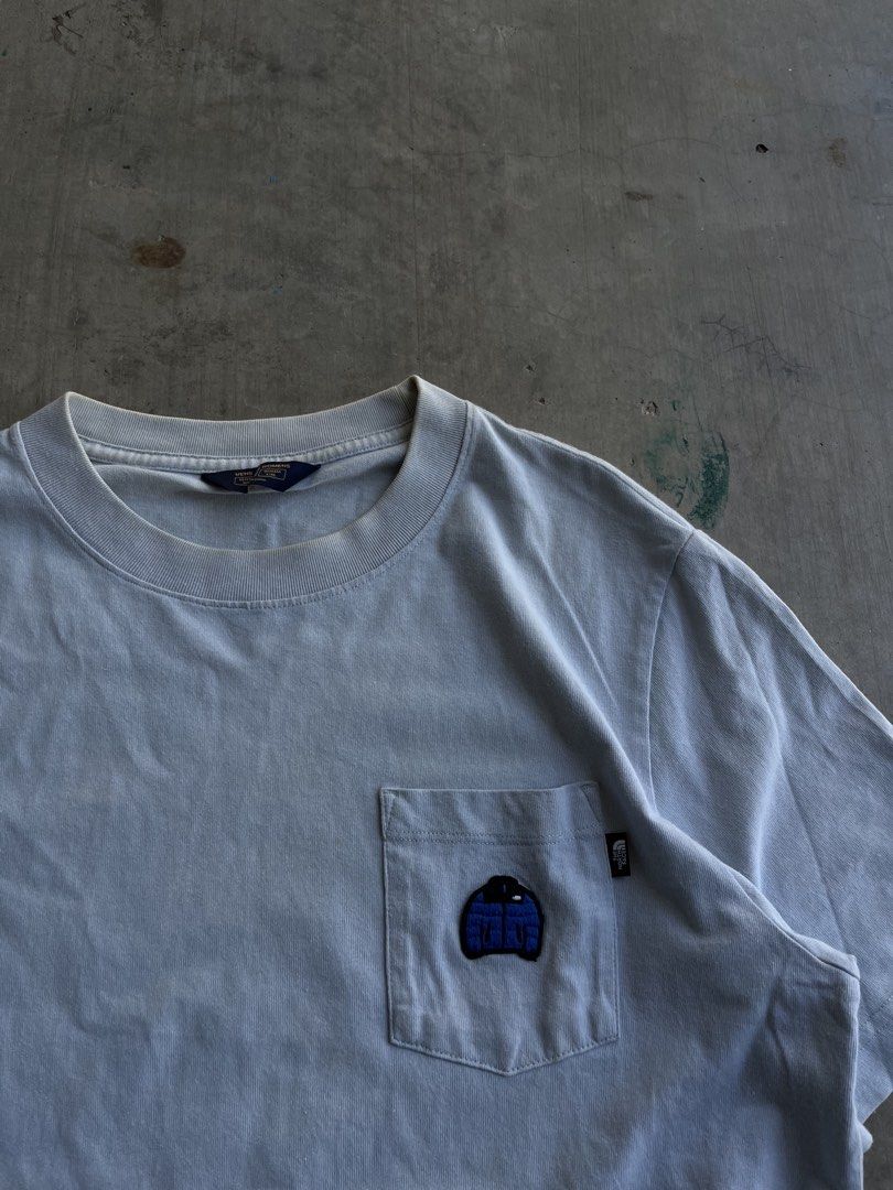 The North Face Puffer Jacket Pocket Tee Light Blue (Category: Coats, Jackets and Outerwear) located in Dipaculao. Submitted by _jzx.ph4lxfe (Listing ID 1470215507, Image 2). Description: - Brand: The North Face - Color: Light Blue - Style: Crew neck casual short sleeve tee with standard fit - Details: Chest pocket with unique embroidered puffer jacket graphic and small black brand tag on the side seam - Condition: Brand new / Excellent - Mode of 