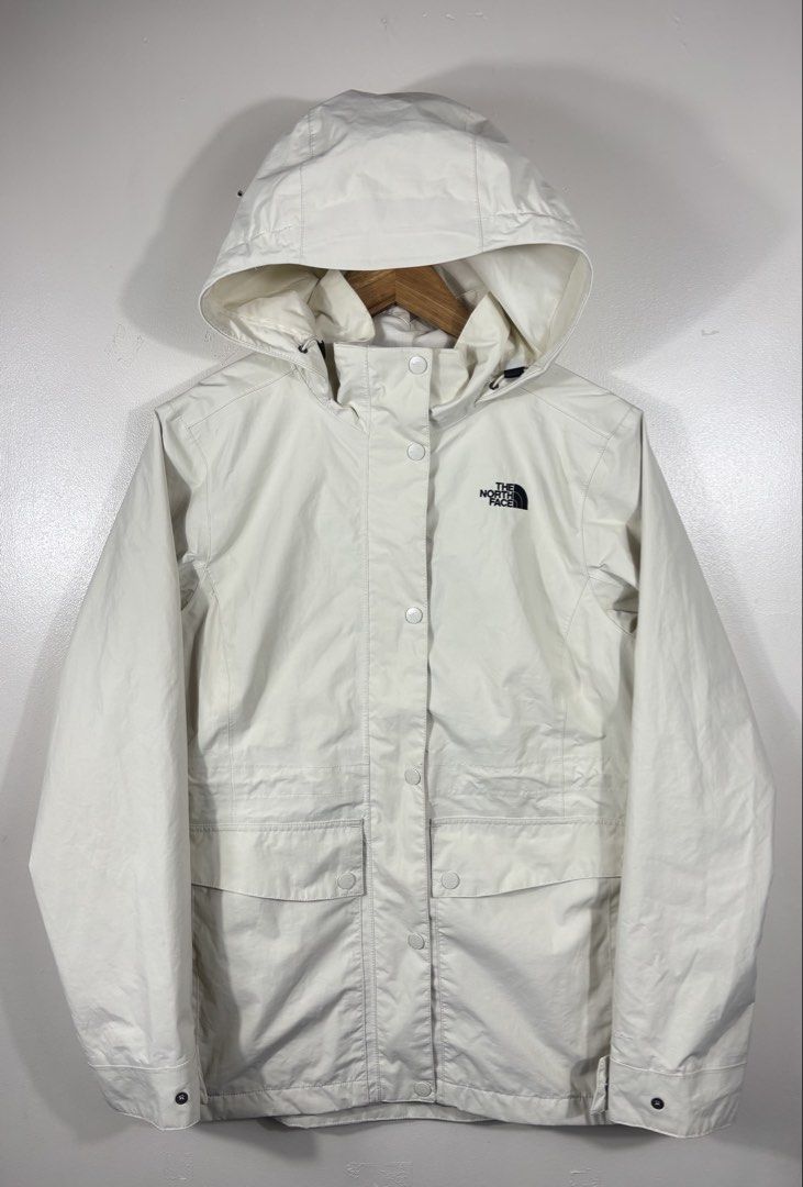 The North Face White Hooded Rain Jacket (Category: Coats, Jackets and Outerwear) located in Manila. Submitted by south_finds (Listing ID 1470220841, Image 1). Description: - Brand: The North Face - Color: Clean Off-White with Black Embroidered Logo - Material: Lightweight, weatherproof fabric - Closure: Full zip with snap button storm flap - Features: Drawstring hood, adjustable cuffs, and two large front flap pockets - Condition: Excellent / Rea