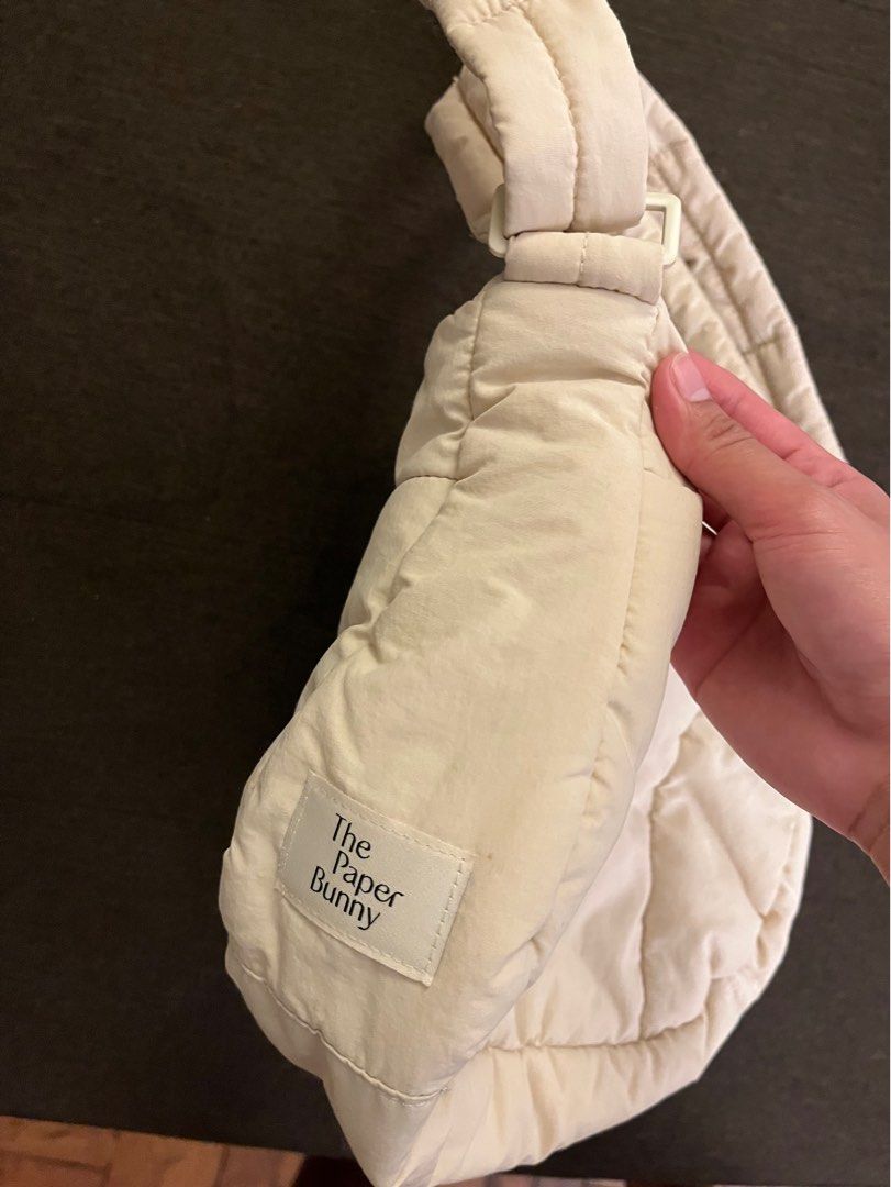 The Paper Bunny Puffer Bag Aspen (Category: Tote Bags) located in Quezon City. Submitted by live_louisee (Listing ID 1470313955, Image 3). Description: - Authentic The Paper Bunny puffer shoulder bag in cream / off-white - Material: Soft and puffy quilted nylon - Closure: Secure zippered main compartment - Pockets: Convenient front pocket for small essentials - Straps: Thick strap designed for comfortable shoulder wear - Details: Subtle embroider