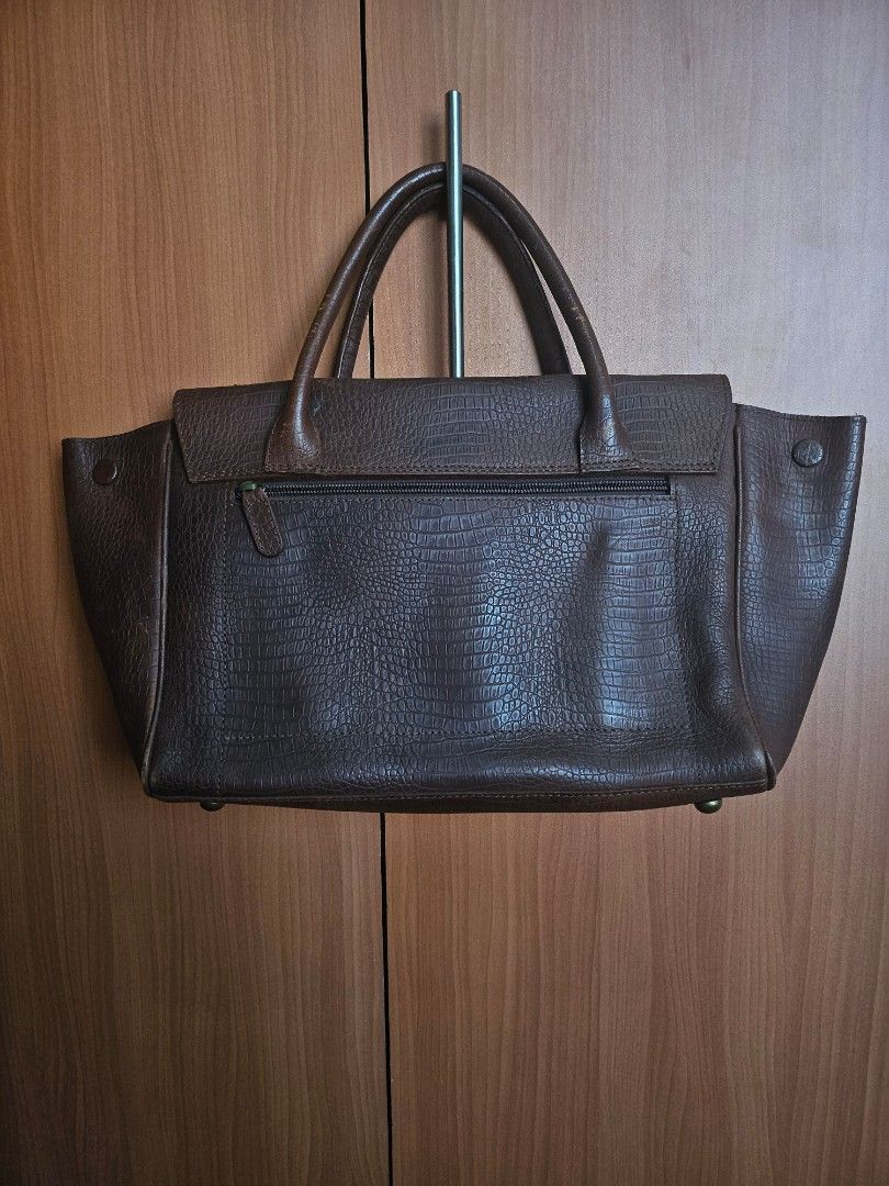 The Tannery Manila Leather Handbag (Category: Shoulder Bags) located in Mandaluyong City. Submitted by ohwmaria (Listing ID 1470227919, Image 3). Description: - Material: Brown embossed leather with reptile-pattern texture - Closure: Secure flap closure with dark metal hardware - Pockets: Multiple exterior and interior zip pockets for easy organization - Interior: Suede lining with branded leather patch label - Design: Structured top handles and 