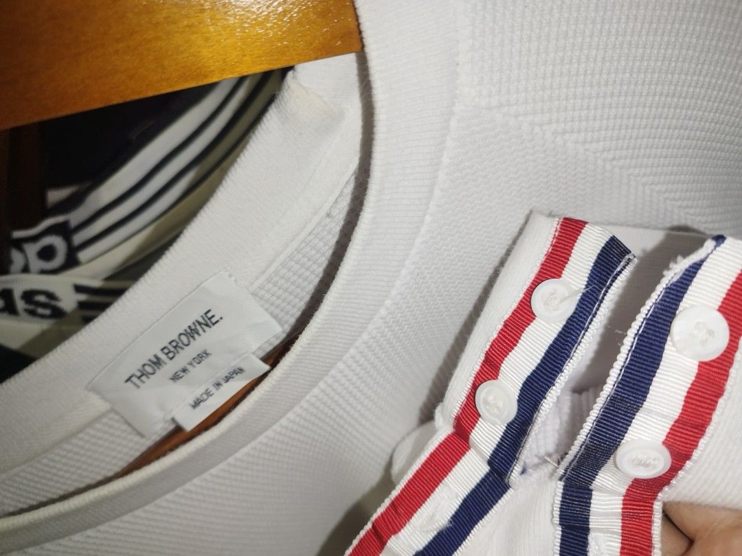 Thom Browne White Waffle Knit Sweatshirt Grey Stripes (Category: Luxury Apparel) located in Tuguegarao City. Submitted by ZeevLim (Listing ID 1470346803, Image 3). Description: - Brand: Thom Browne New York - Color: White with grey 4-bar stripes - Material: Premium waffle knit texture - Origin: Made in Japan - Details: Tricolor grosgrain ribbon tab at back collar - Cuffs: Button cuffs with red, white, and blue striped placket lining - Style: Luxu