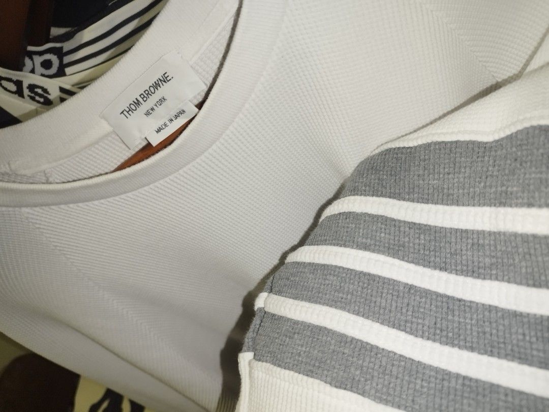 Thom Browne White Waffle Knit Sweatshirt Grey Stripes (Category: Luxury Apparel) located in Tuguegarao City. Submitted by ZeevLim (Listing ID 1470346803, Image 2). Description: - Brand: Thom Browne New York - Color: White with grey 4-bar stripes - Material: Premium waffle knit texture - Origin: Made in Japan - Details: Tricolor grosgrain ribbon tab at back collar - Cuffs: Button cuffs with red, white, and blue striped placket lining - Style: Luxu
