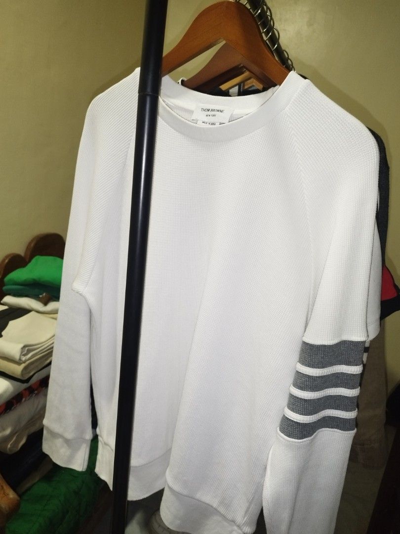 Thom Browne White Waffle Knit Sweatshirt Grey Stripes (Category: Luxury Apparel) located in Tuguegarao City. Submitted by ZeevLim (Listing ID 1470346803, Image 1). Description: - Brand: Thom Browne New York - Color: White with grey 4-bar stripes - Material: Premium waffle knit texture - Origin: Made in Japan - Details: Tricolor grosgrain ribbon tab at back collar - Cuffs: Button cuffs with red, white, and blue striped placket lining - Style: Luxu