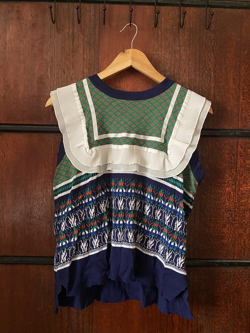 [THRIFTED & AVAILABLE] Multicolored Patterned Knitted Sweater Vest (Category: Sleeveless) located in Quezon City. Submitted by yaku1t (Listing ID 1470189717, Image 2). Description: SHIPPING FROM QUEZON CITY. Kindly, read the caption and the bio for some house rules. Swipe right for the close-up pictures. Item is thrifted, please, manage expectations. - Free Size (best fits M) - Geometric green top section with colorful tribal-style print on the l