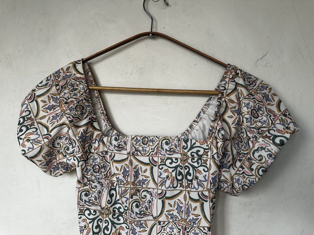 Tile Print Puff Sleeve Square Neck Romper (Category: Rompers) located in Manila. Submitted by omelette.12 (Listing ID 1470246295, Image 3). Description: - Style: Short one-piece romper with pleated shorts - Design: White base with vibrant multi-color Mediterranean tile pattern - Details: Chic square neckline, trendy puff sleeves, and a flattering fitted waist - Perfect for: Warm weather, sunny days out, or weekend brunch - Fit: Easy to slip on an