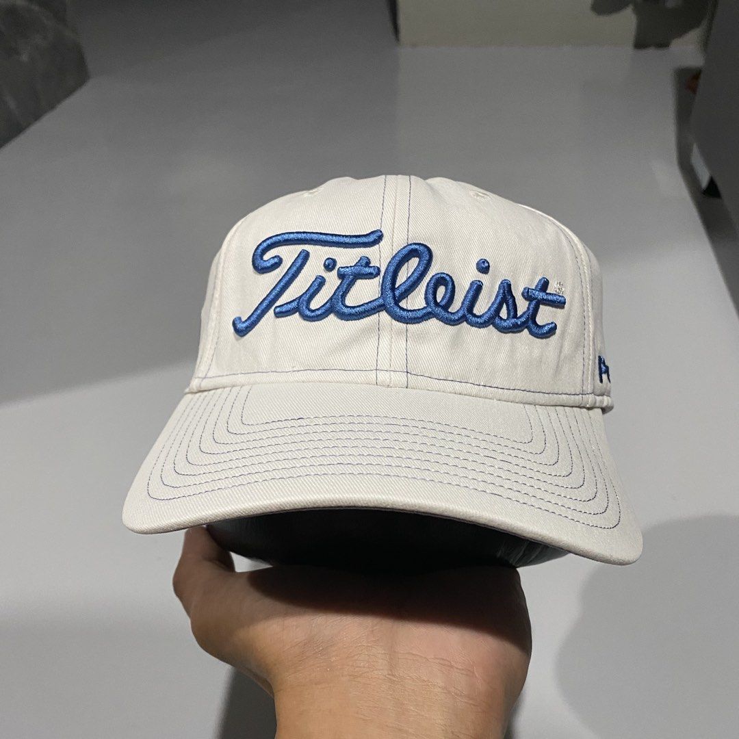 Titleist Pro V1 Golf Cap White Blue Adjustable (Category: Caps & Hats) located in Villasis. Submitted by thriftngrind (Listing ID 1470286821, Image 1). Description: - Authentic Titleist golf hat in clean white fabric - Stylish blue embroidered lettering on the front - Pro V1 logo on one side and FJ logo on the other - Titleist text embroidered on the back strap - Structured brim with contrast blue stitching - Adjustable metal buckle clasp with en